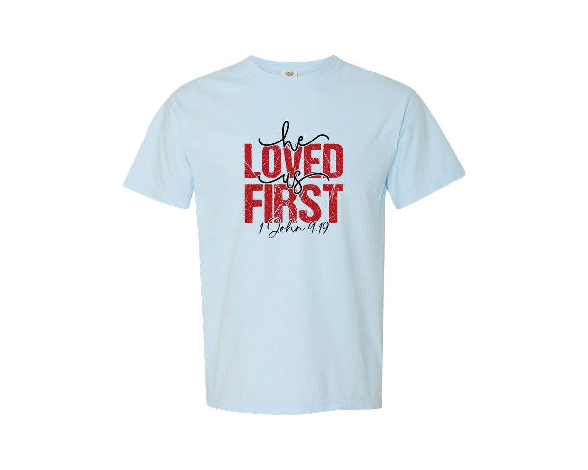 brand:Comfort Colors|color:Chambray|He Loved Us First Christian Graphic T-Shirt