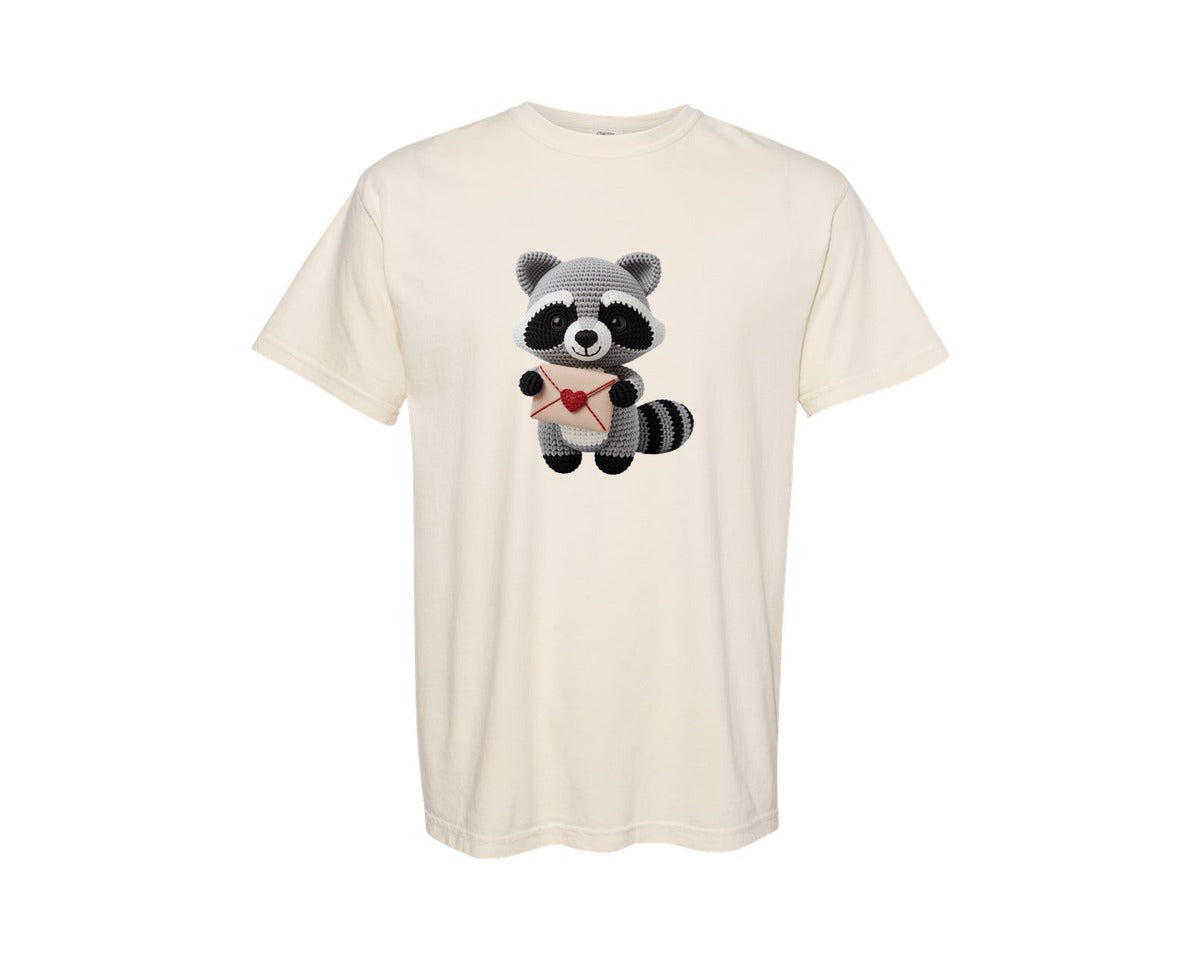 brand:Comfort Colors|color:Ivory|Crochet Raccoon Holding Love Letter Graphic T-Shirt