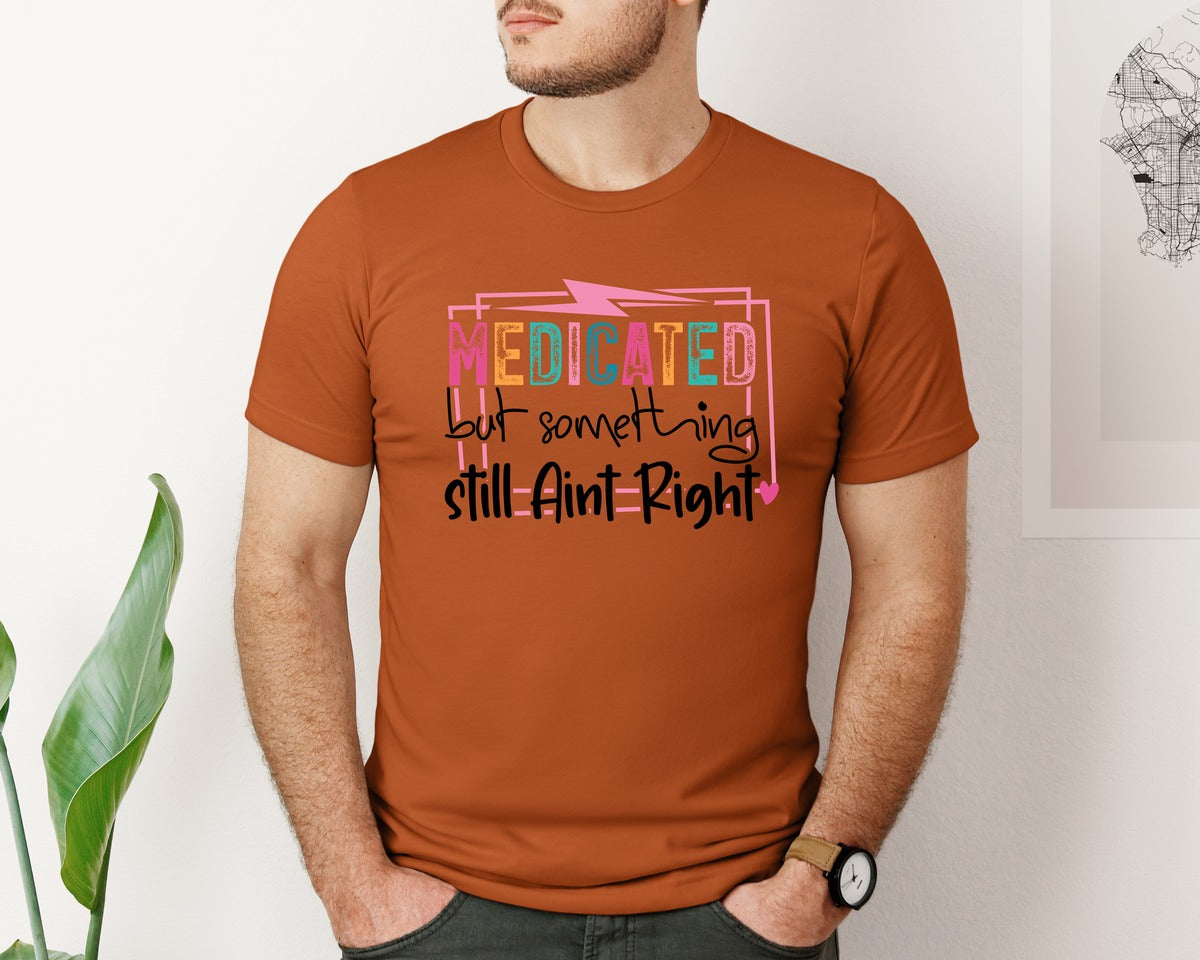 brand:Bella Canvas|color:Autumn|Medicated But Somethin Aint Right Snarky Graphic T-Shirt