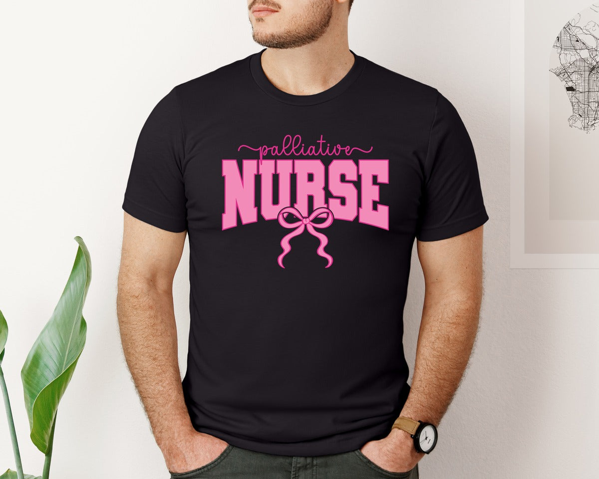 brand:Bella Canvas|color:Black|Palliative Nurse Coquette Nurse Pink Bow Graphic T-Shirt