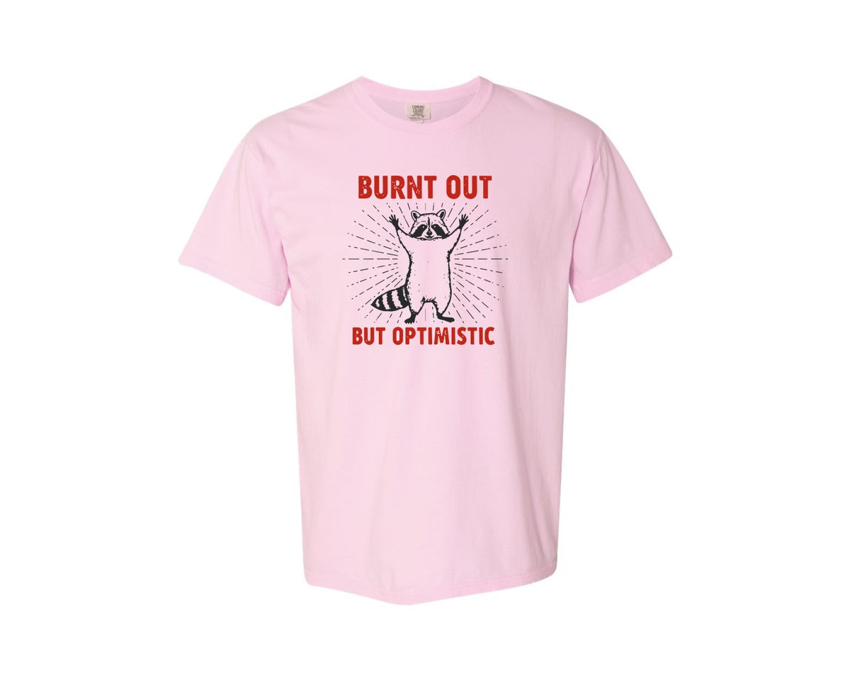 brand:Comfort Colors|color:Blossom|Burnt Out But Optimistic Raccoon Graphic T-Shirt
