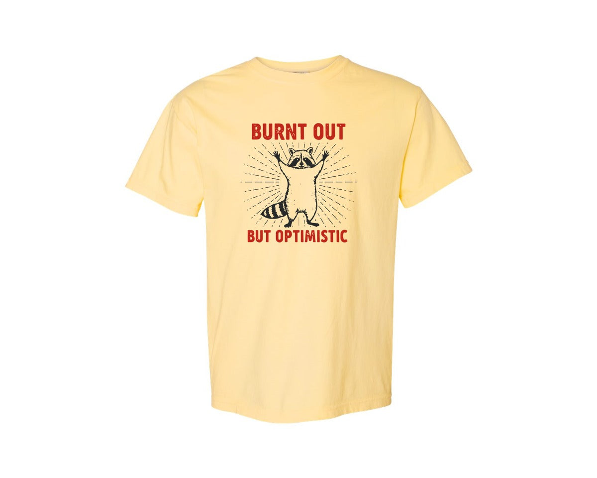 brand:Comfort Colors|color:Butter|Burnt Out But Optimistic Raccoon Graphic T-Shirt