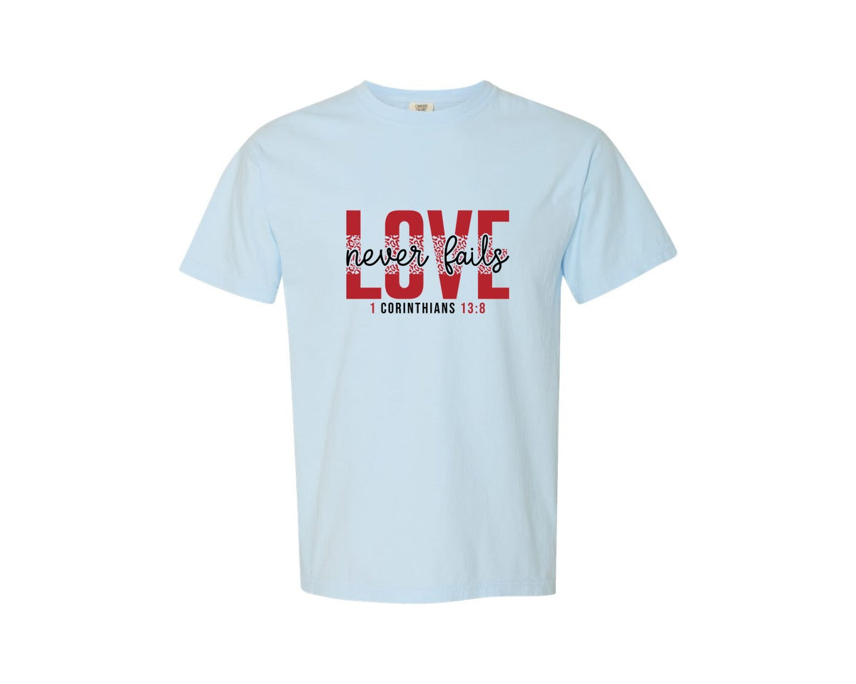 brand:Comfort Colors|color:Chambray|Love Never Fails Svgfaith Valentine Graphic T-Shirt