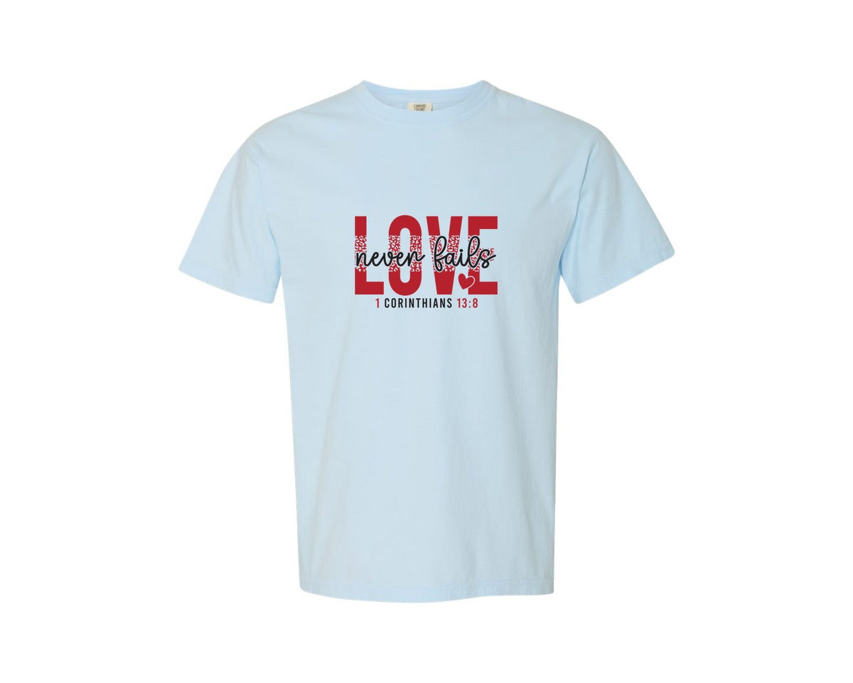 brand:Comfort Colors|color:Chambray|Love Never Fails Faith Valentin Graphic T-Shirt