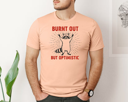 brand:Bella Canvas|color:Heather Peach|Burnt Out But Optimistic Raccoon Graphic T-Shirt