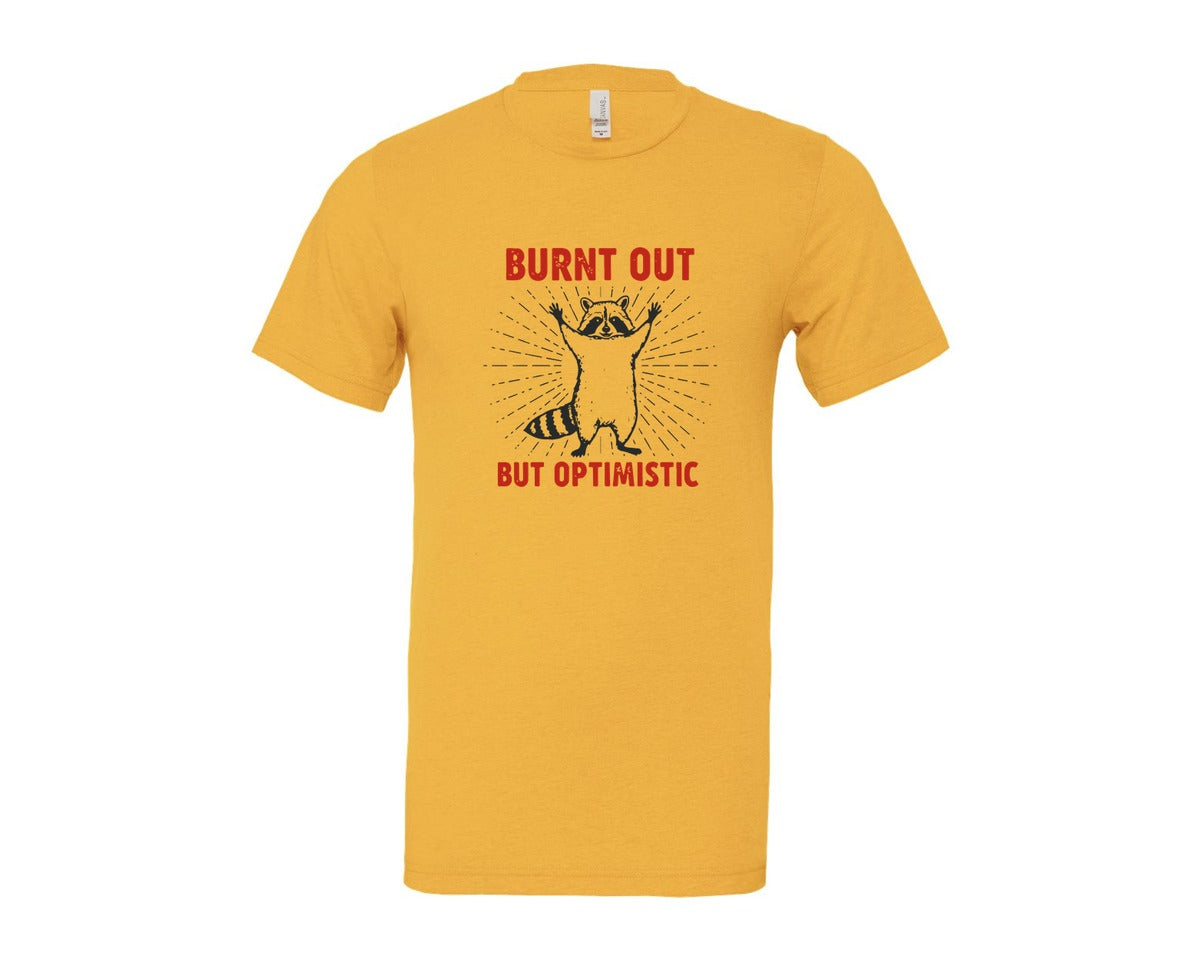 brand:Bella Canvas|color:Heather Yellow Gold|Burnt Out But Optimistic Raccoon Graphic T-Shirt