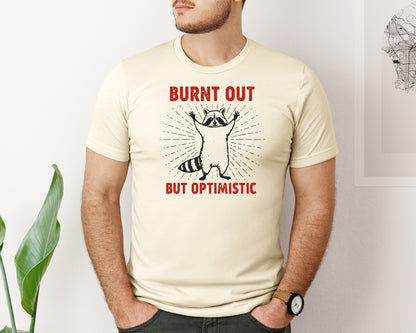 brand:Bella Canvas|color:Light Cream / Natural|Burnt Out But Optimistic Raccoon Graphic T-Shirt