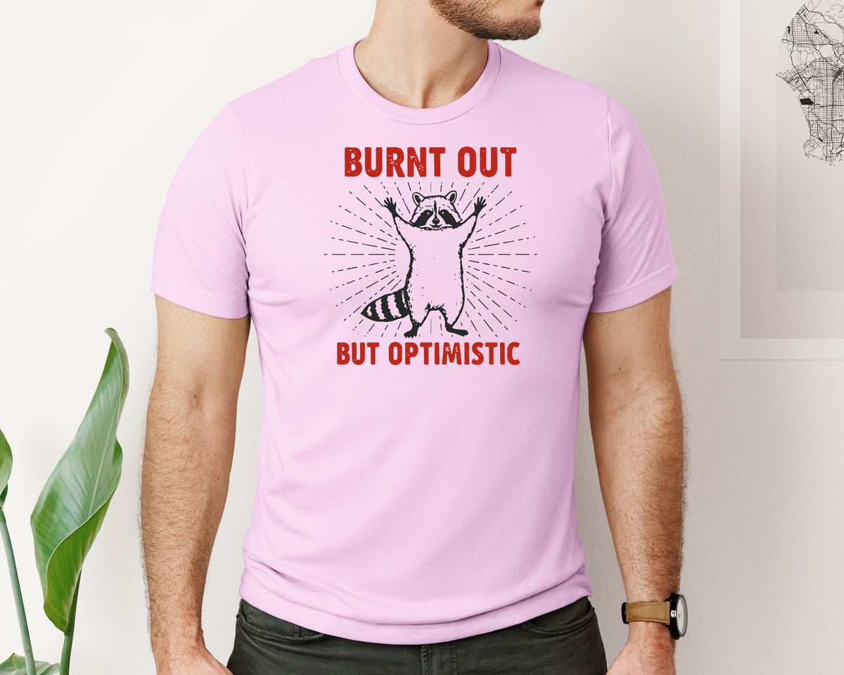 brand:Bella Canvas|color:Lilac|Burnt Out But Optimistic Raccoon Graphic T-Shirt