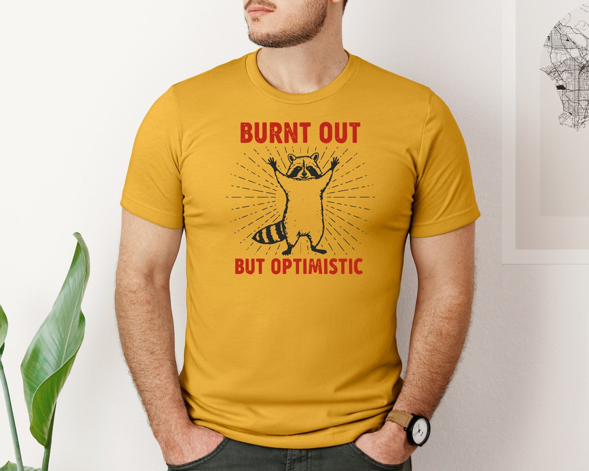 brand:Bella Canvas|color:Mustard|Burnt Out But Optimistic Raccoon Graphic T-Shirt
