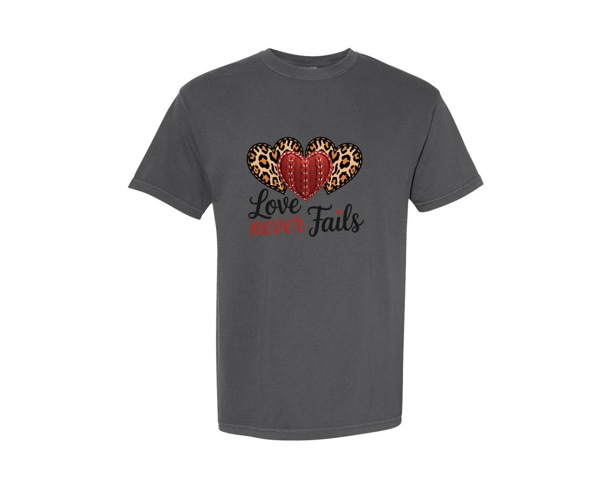 brand:Comfort Colors|color:Pepper|Love Never Fails Faith Based Valentine Graphic T-Shirt