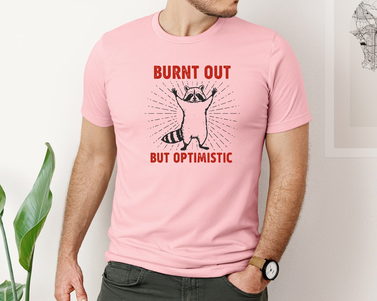brand:Bella Canvas|color:Pink|Burnt Out But Optimistic Raccoon Graphic T-Shirt